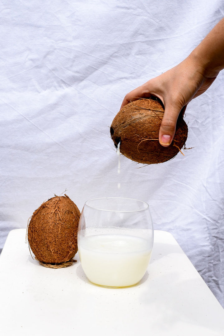 Glass of coconut milk next to a curry dish