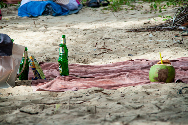 Can of CocoCruz coconut water surrounded by fresh coconuts